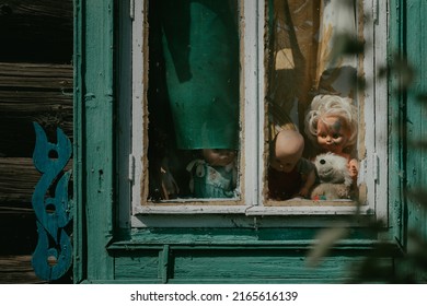 Scary Children's Dolls And Toys Look Out Of The Window Of An Old Abandoned Wooden House