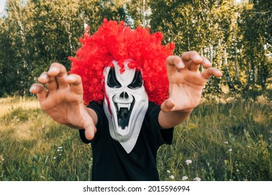 Scary Clown Kid  On Halloween Looks At The Camera And Takes Pictures. Traditions, Holidays Concept