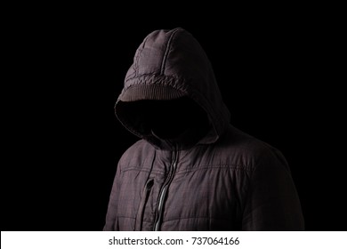 Scary and creepy man hiding in the shadows, with the face and identity hidden with the hood, and standing in the darkness. Low key, black background. Concept for fear, mystery, danger, crime, stalker - Shutterstock ID 737064166
