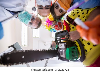Scary delusion with dental team and crazy clown with chainsaw in bottom view