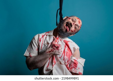 Scary Demon Hanged At Gallows With Hanging Rope, Suicidal Creepy Zombie At Execution In Front Of Studio Camera. Spooky Dangerous Corpse Hangs From Knot Thinking About Suicide.