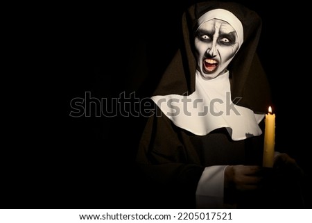 Scary devilish nun with burning candle on black background, space for text. Halloween party look