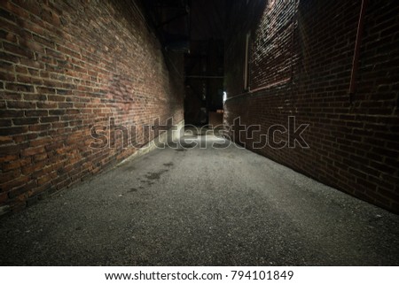 Scary empty dark alley with brick walls