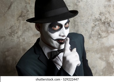Scary evil clown wearing a bowler hat on wall background - Shutterstock ID 529222447