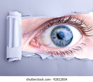 scary eye looking trough ripped paper