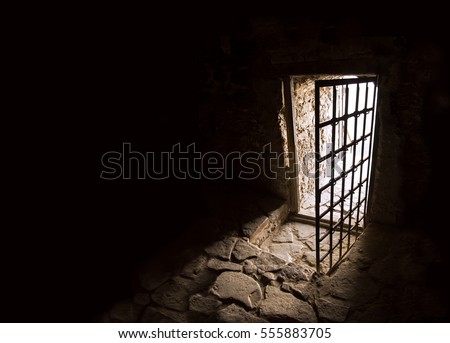 Scary fort cold dirty home iron grate rock brick trap cell wall floor. Gaol gloomy spooky fear shadow walk go rusty hallway way lead release day sky sunlight glow light lit text space backdrop symbol