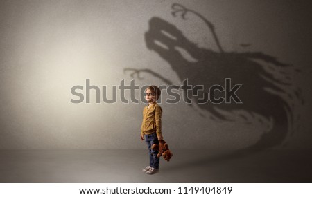 Scary ghost shadow in a dark empty room with a cute blond child