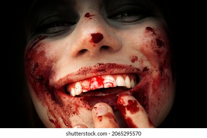 Scary Girl In The Image Of A Vampire .
Halloween Theme Portrait Of Crazy Girl With Bloody Face. Zombie Theme, Black Background, Isolated, Killer. 