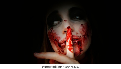 Scary Girl In The Image Of A Zombie.
Halloween Theme Portrait Of Crazy Girl With Bloody Face. Zombie Theme, Black Background, Isolated, Killer. Banner, Copy Of The Space. 