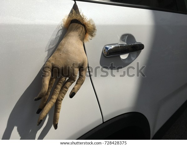 Scary Halloween hand\
stuck in car door scary holiday prank decoration for the American\
holiday of Halloween