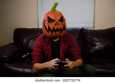 Scary Halloween Pumpkin Man Playing Video Games In The Living Room.  Jack O Lantern Man