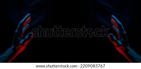 A scary hand on dark background. Mysterious composition. Fortune teller, mind power, prediction, halloween concept. Wide angle horizontal wallpaper or web banner. Mockup for your logo.