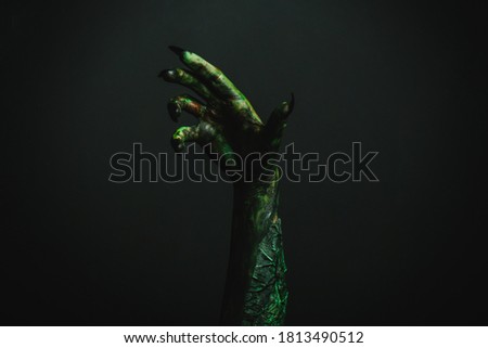 Scary monster on black background, closeup of hand. Halloween character
