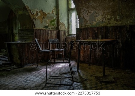 Scary rotten and moldy abandoned cellar with a table and some chairs