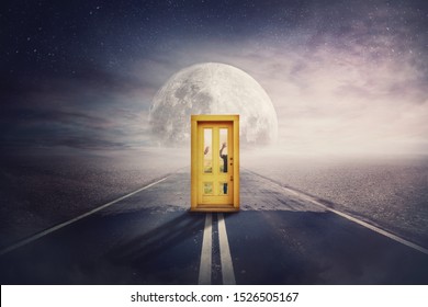 Scary Scene With Spirit Silhouettes Coming From Another World, Parallel Universe, Try To Open A Door In The Middle Of A Road. Spooky Hands Pushing Behind Doorway, Try To Enter. Mystic Way To Full Moon