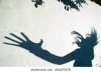 Scary Shadow Of A Person With A Very Big Hand On A White Wall