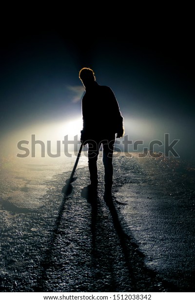 Scary silhouette\
of a man with axe in night\
