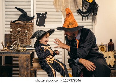 Scary Stories. Horror. Father Tells His Son A Terrible Fairy Tale For The Night Of Halloween. Playing Game At Halloween Party. Holiday With Funny Carnival Costumes With A Skeleton And A Magician