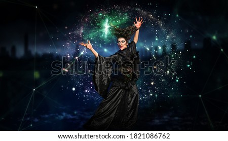 scary witch confuring a spell in front of Halloween background