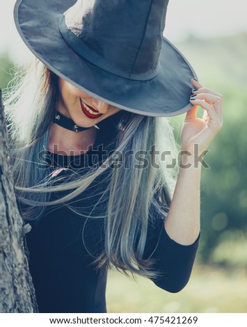 Similar – Blonde junge Frau mit Hut und Sonnenbrille, die bei Sonnenuntergang im Wald mit einem Mobiltelefon ein Foto macht.