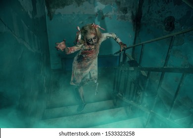 Scary Zombie Girl Is Standing On The Stairs. Halloween. Horror Movie.