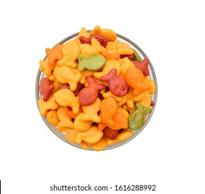 A Scaterring Of Colorful Goldfish Crackers In Glass Bowl On White