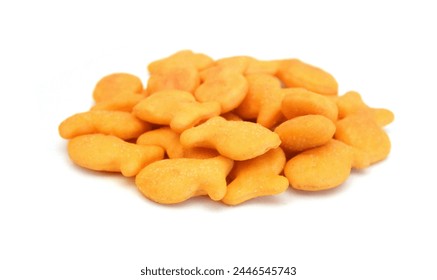 A scaterring of yellow goldfish crackers in glass bowl on white