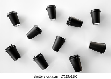 Scattered black paper cups close up on a white background. Recycling craft paper cups of coffee to go. Selective focus. Craft cup for hot beverage, takeaway. Disposable cup. Minimalist Style - Powered by Shutterstock