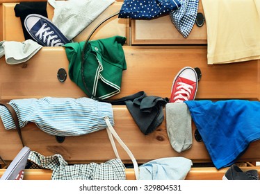 Scattered Clothes And Shoes In The Drawers Of The Dresser