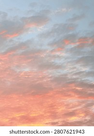 Scattered clouds fill the sky with soft pink, orange, and pale blue hues during twilight. No visible horizon or landmarks. Ideal for backgrounds or atmospheric visuals.