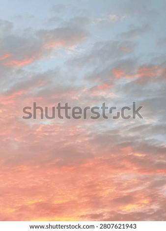 Scattered clouds fill the sky with soft pink, orange, and pale blue hues during twilight. No visible horizon or landmarks. Ideal for backgrounds or atmospheric visuals.