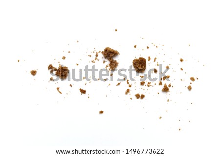 Scattered crumbs of chocolate chip butter cookies on white background.