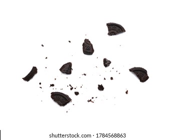 Scattered crumbs of chocolate sandwich cookies filled with sweet cream flavored isolated on white background.