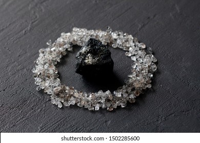 Scattered diamonds on a black background. Raw diamonds and mining, a scattering of natural diamond stones. Graphite quartz. Natural stones and minerals. Stone black tourmaline, sherl.