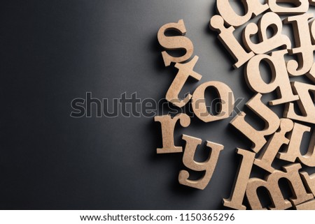 Scattered English letters with STORY word on black plastic background