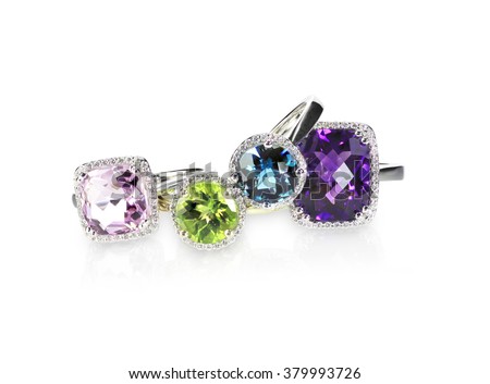 Scattered gemstone and diamond halo fine jewelry rings in a grouping
