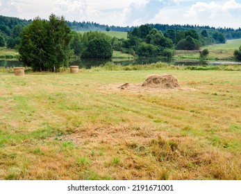 Scattered Hay Stack On Mowed Field Near River After Summer Rain