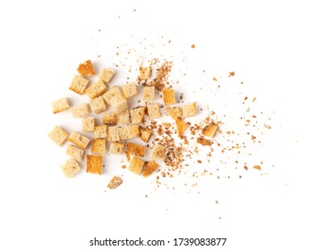 Scattered homemade bread croutons with crumbs isolated on white background top view. Crispy bread cubes, dry crumbs, rusks, crouoton or white roasted crackers cube heap
