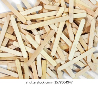 Scattered Pile Of Wooden Brown Popsicle Sticks.