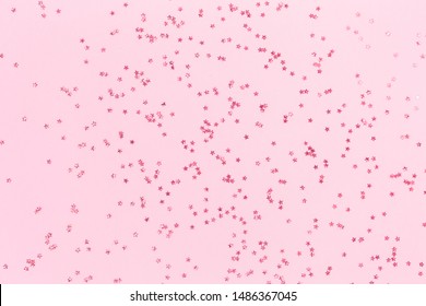 Scattered Pink Holographic Glitter Confetti Star Shaped On Candy Pink Background Flat Lay Top View Copy Space. Festive Holiday Pastel Backdrop. Birthday, Giveaway, Christmas, New Year