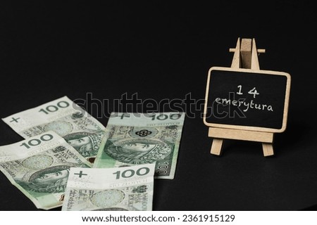 scattered Polish money on a black background, next to it there is a writing board with the inscription 