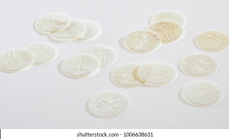 Scattered sacramental Hosties on a white background symbolic of the body of the resurrected Christ used in Holy Communion