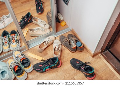 Scattered shoes on the corridor floor. Shoes in the apartment. Women's sneakers.