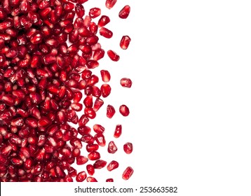 scattered from the side fresh pomegranate seeds, can be used as a background, isolated on a white