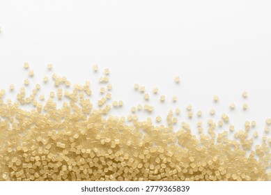 Scattered translucent plastic granules create clean abstract wave with copy space for recycling, manufacturing and material design.