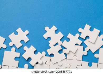 scattered white jigsaw puzzle pieces on blue background. - Shutterstock ID 2065887791