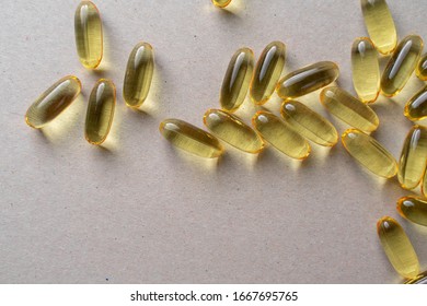 Scattering Of Fish Oil Pills On A Light Gray Background. Translucent Gelatin Capsules