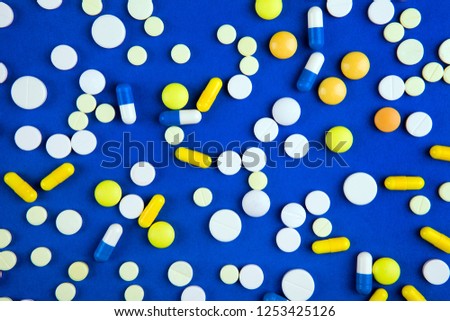 Scattering Pills on the Blue Paper Background closeup