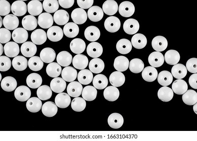 A Scattering Of White Beads On A Black Background