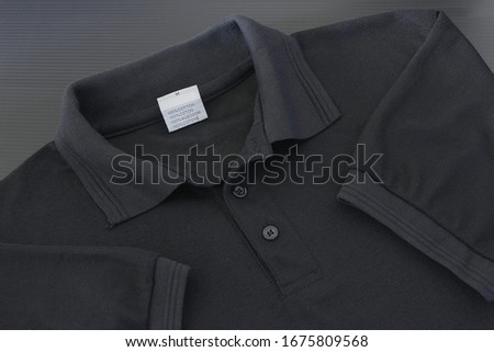 The​ collar​ of​ a​ black​ T-shirt​ on​ dim​ light​ scene
